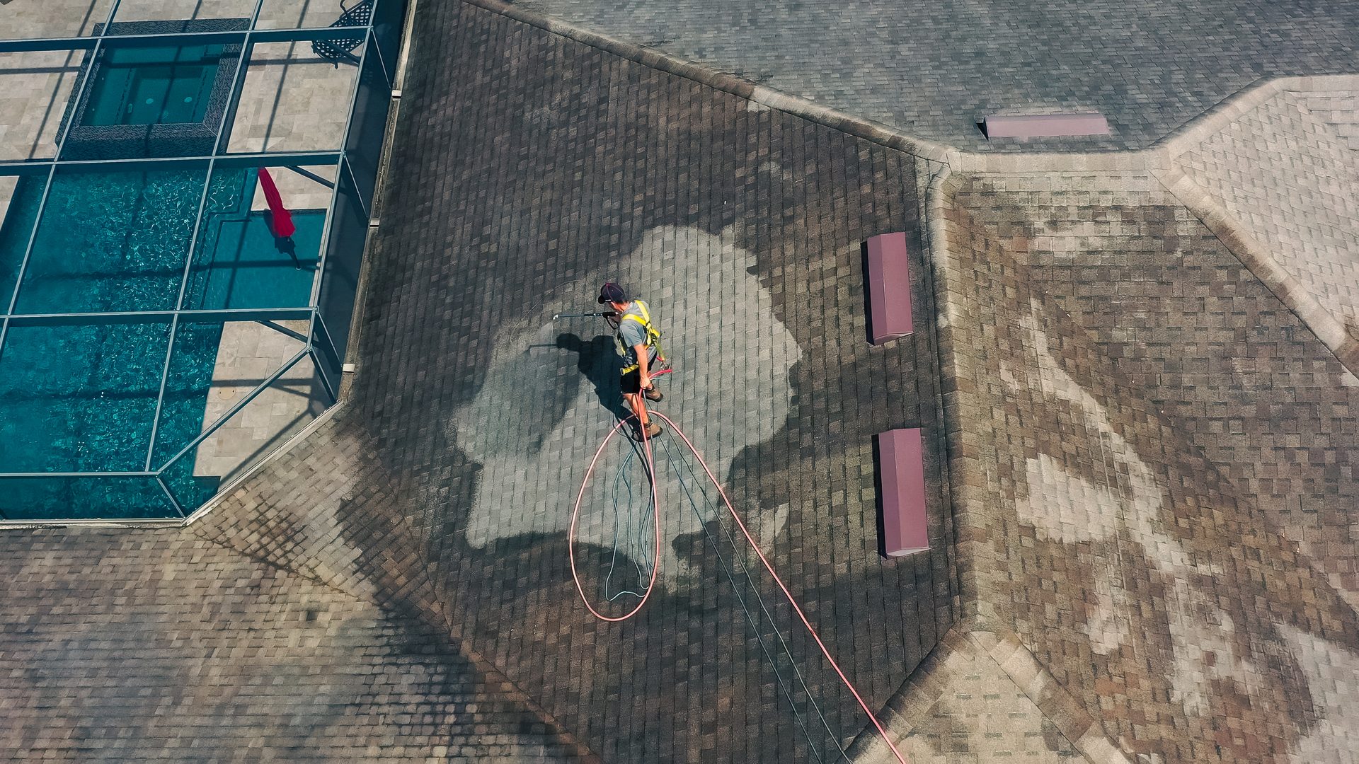 Overhead view of technician safely cleaning a Florida roof
